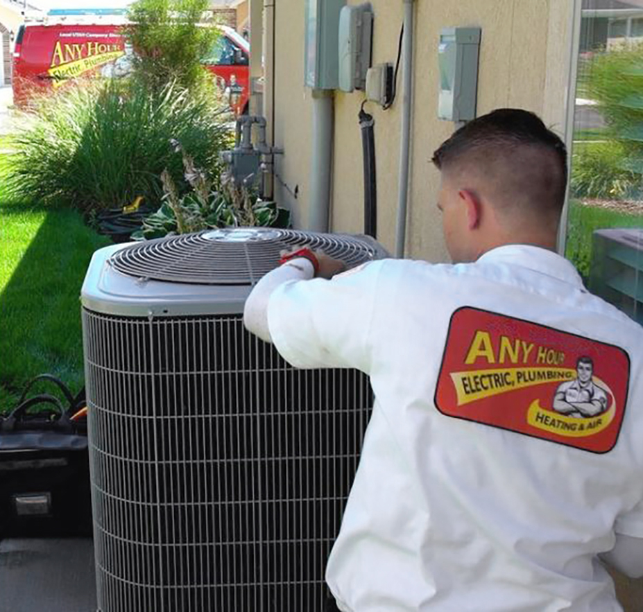 HVAC tech examining an AC unit. R-410A Refrigerant is being phased out.